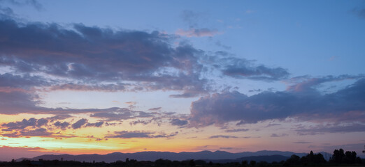 Naklejka premium Colorful sunset and sunrise with clouds.Blue and orange color of nature.Many white clouds in the blue sky.The weather is clear today.sunset in the clouds.The sky is twilight.