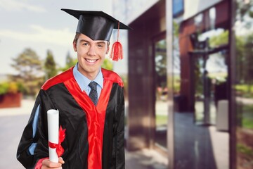 Portrait of handsome male graduate in a graduation robe