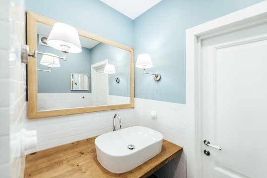 Blue washroom with a wood top and a white sink