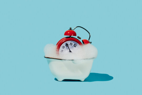 red alarm clock in a bathtub
