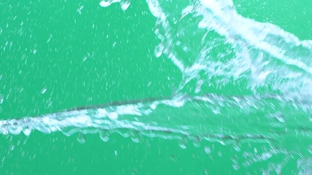 Slow motion of water spash with drops over green screen chroma key background
