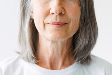 Grey senior woman in t-shirt posing at camera