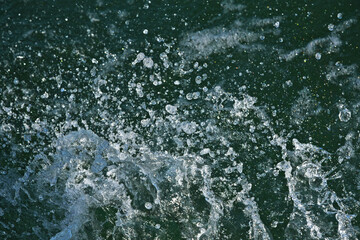 Light sea spray on a dark green-blue background, close-up
