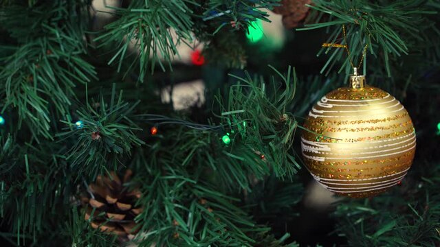 Close-up view of an artificial christmas tree decorated with golden balls and garlands. Christmas or New Year background.