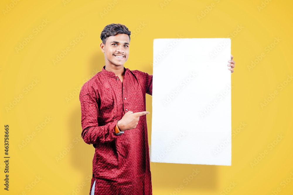 Wall mural young indian man holding white board while wearing traditional cloths - Wall murals