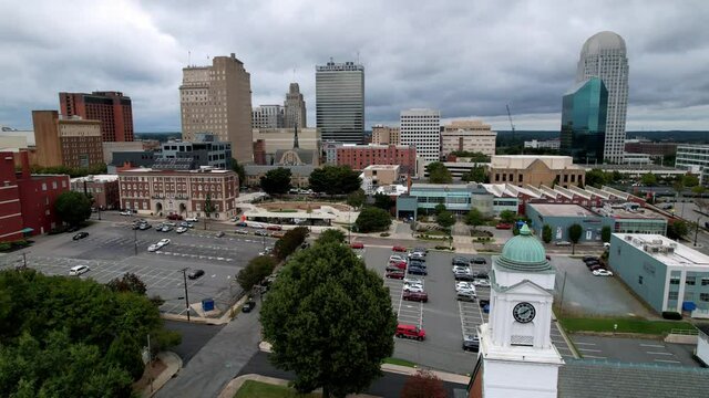 aerial push over moravian church steeple into winston salem skyline
