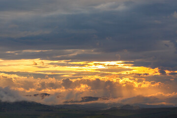 Sunset over mountain landscape with clouds