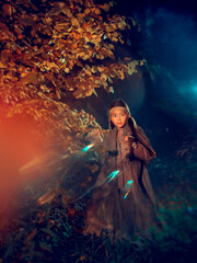 Obraz na płótnie Canvas Young girl in national costume in the mystery fall night forest