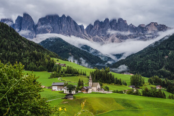 St Magdalena church in Val di Funes valley, Dolomites, Italy. Furchetta and Sass Rigais mountain peaks in background