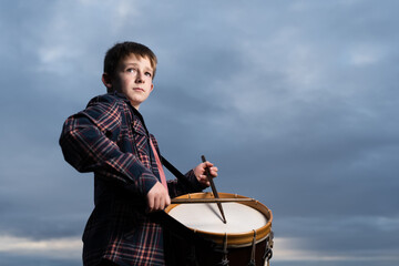 Dramatic portrait of a musician playing a classic snare drum.