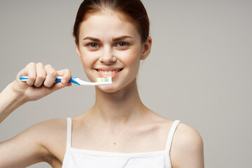 pretty woman toothpaste brushing teeth dental health light background