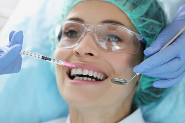 A woman is given an injection before a dental procedure