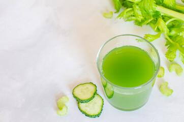 Fresh celery and cucumber juice. Green healthy drink in a glass on a white background. Detox diet, pure organic food, with vegetables