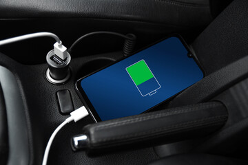 Mobile phone ,smartphone, cellphone is charged ,charge battery with usb charger in the inside of car. modern black car interior
