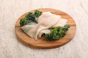 Raw squid over wooden board