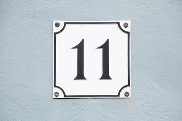 Hausnummernschild Nr. Elf auf heller Hauswand, Deutschland, Europa
