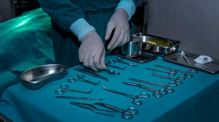 Fototapeta na wymiar Surgical medical instruments and tools including scalpels, forceps and tweezers prepared on the table for treatment patient in operation hospital room. 