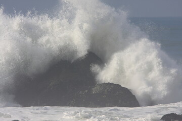 storm surf breaking on large rocks in California 