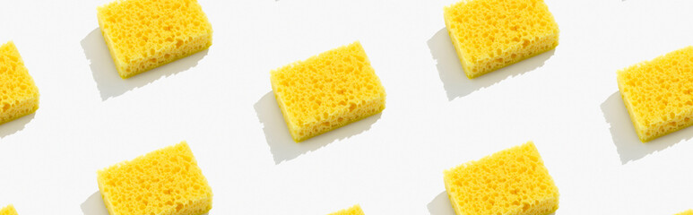Creative layout with yellow sponge for dishwashing on gray background