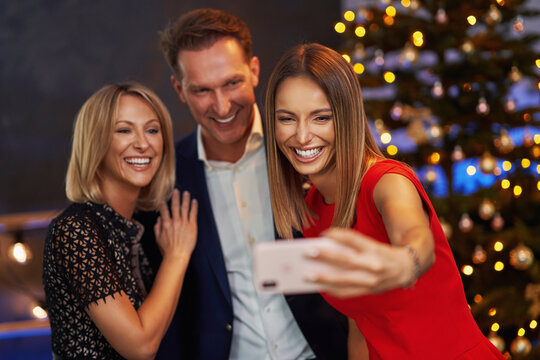 Business friends celebrating christmas party taking selfie