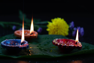 Eco Friendly Handcrafted Colorful Clay Diya Deep Or Dia Illuminated On Green Leaf With Flowers....