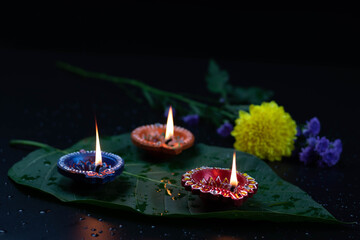 Eco Friendly Handcrafted Colorful Clay Diya Deep Or Dia Illuminated On Green Leaf With Flowers....