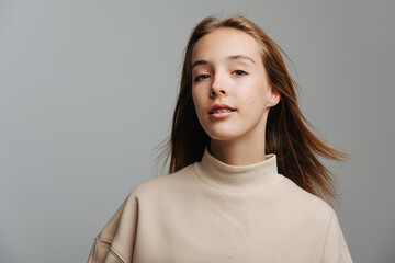 Portrait of a pretty teenage girl with brackets against grey background. - obrazy, fototapety, plakaty