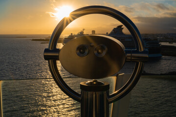 Binoculars on a cruise ship overlooking the sea at sunset