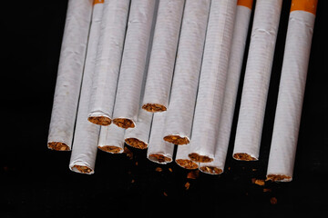 Back side view of cigarettes and Bidi on black background,cigarette butt on wooden table with black background,dry tabacco,world No Tobacco Day concept