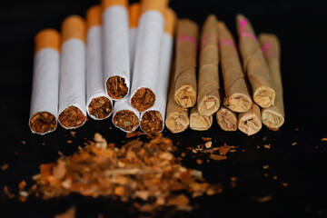 Tobacco bidi and cigarettes on black background with selective focus,Bidi,Cigarette Locally called a Bidi, tobacco and bidi,dry tabacco © Dinesh
