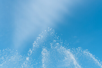 Blue sky with splashes and drops of water. Blurred abstract refreshing background.