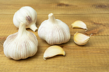 Heads and cloves of garlic on wooden table. Natural antiviral and antibacterial agent in alternative medicine.