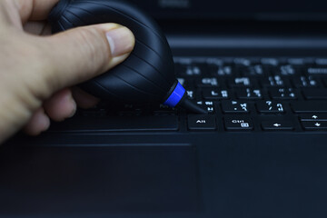 Cleaning the keyboard with a small inflatable ball.