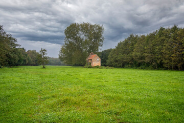 old derelict abandoned farm building barn cottage isolated in a field surrounded by woodland on a flood plane - obrazy, fototapety, plakaty