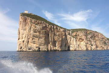 Lighthouse on Limestone cliffs of the Capo Caccia cape at the Gulf of Alghero, Sardinia, Italy