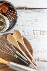 Kitchen utensils, measuring cups, whisk , cake mold and wooden spoon on white vintage wooden...