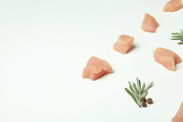 Flat lay composition with slices of raw chicken fillet on white background