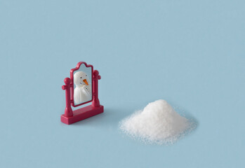 Snowman with mirror on pastel blue background. Minimal New Year and  Christmas concept.