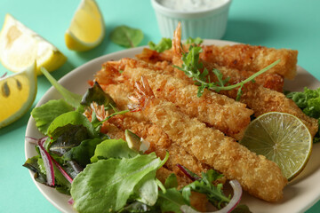 Сoncept of tasty food with deep-fried shrimp on mint background
