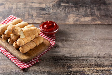 Latin American tequeños stuffed with cheese on wooden table.Copy space