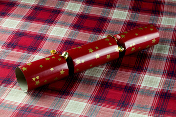 Red Christmas Cracker on a Tartan Table Cloth