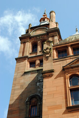 Fototapeta na wymiar Stone Public Building with Cupola & Chimney seen from below against Blue Sky 