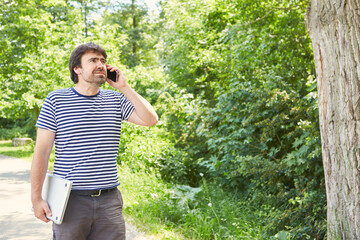 Freiberufler telefoniert mit dem Smartphone im Garten