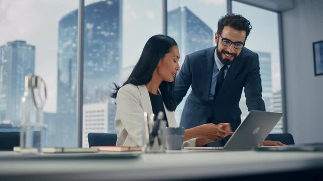 Modern Office: Successful Corporate CEO Sitting at Her Desk Working on Laptop and Consulting Top manager. Businesspeople Discuss Investment in Digital e-Commerce Fintech Startup. Medium Portrait