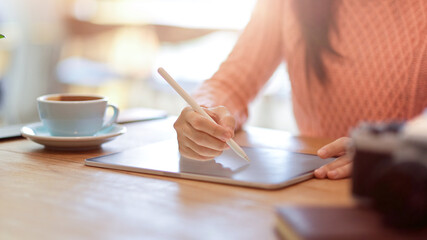 Female college student doing homework, online learning, make a lecture on digital tablet computer.