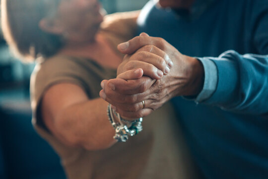 senior couple dancing hand in hand - elderly taking tango course