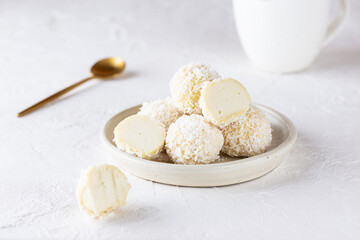 Vegan coconut truffles on a light background. Sugar, gluten and lactose free.