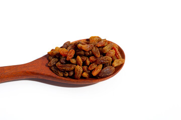 Dried grape raisins in wooden spoon on white background