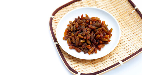 Dried grape raisins in plate on white background