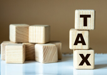 TAX - word nadrevyannye cubes on a brown background